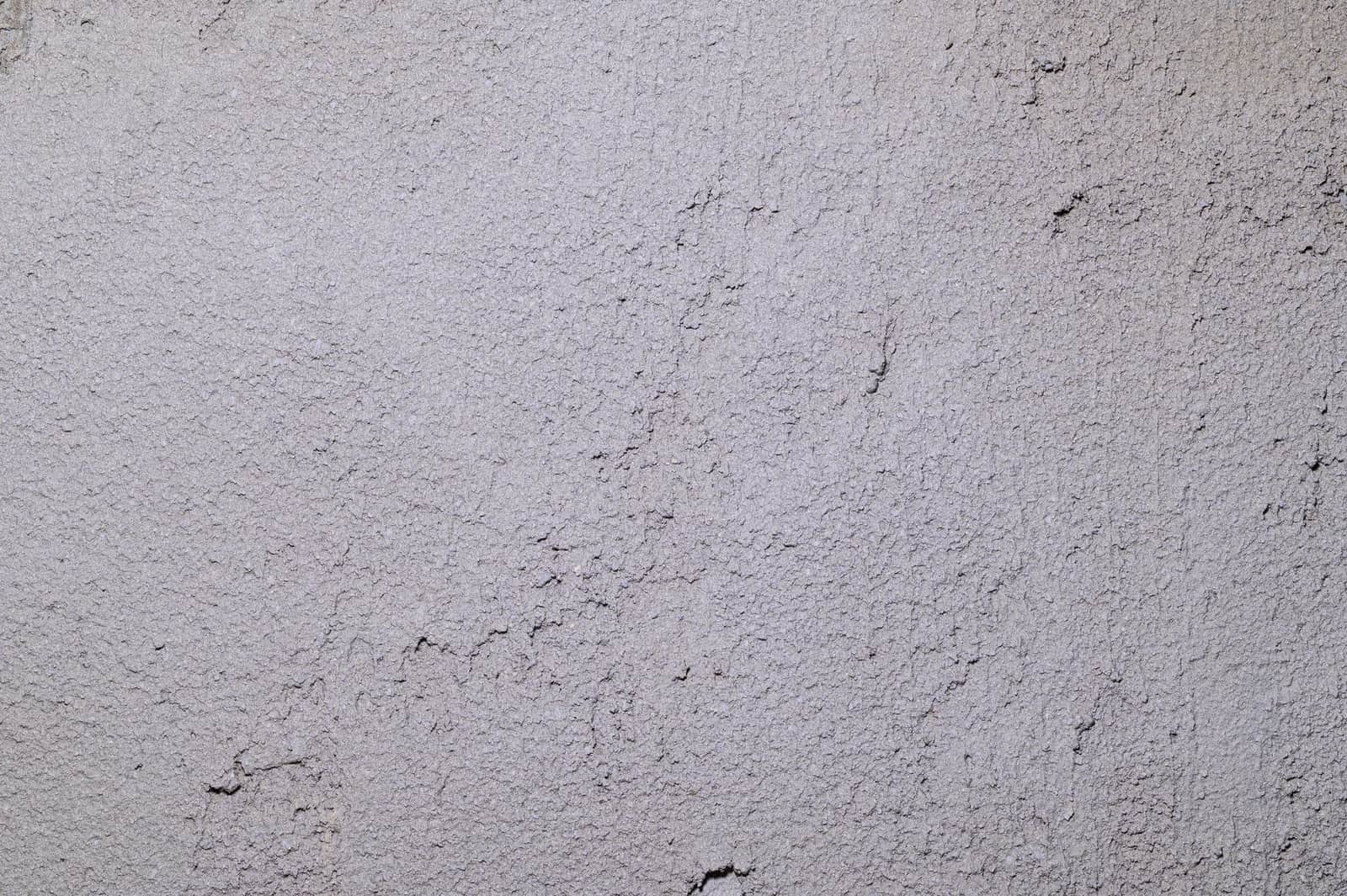 Close-up of a gray stucco wall showing rough, textured surface ideal for backgrounds.